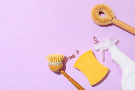 Set of cleaning supplies and spray bottle on color background