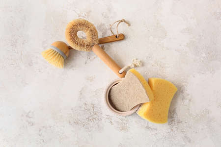 Different cleaning supplies on grunge background