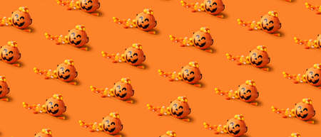 Baskets with tasty candy corns for Halloween on orange background