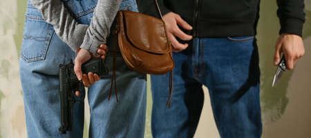 Male thief going to attack woman with gun for self-defence, closeup