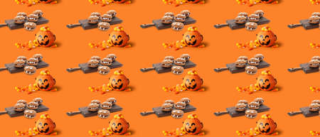 Tasty desserts for Halloween party on orange background