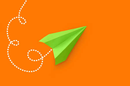 Green paper plane on orange backgroundの写真素材