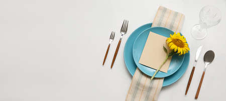 Beautiful table setting with fresh sunflower on light background with space for text, top view