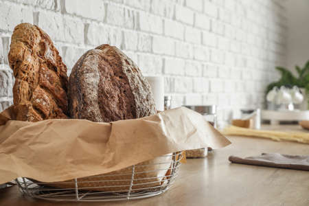 Basket with loaves of fresh bread on counter in kitchen