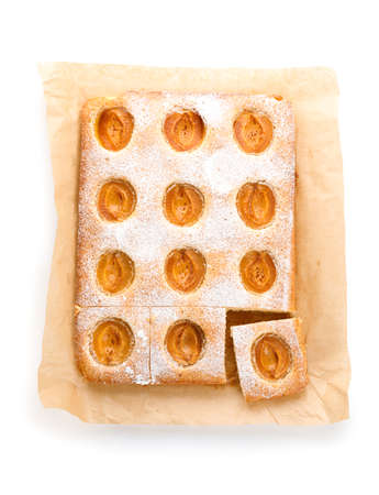 Baking parchment with tasty apricot pie on white backgroundの写真素材