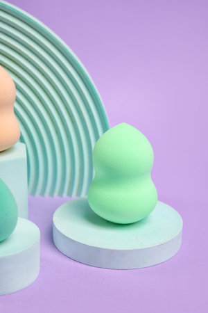 Makeup sponge with decor on violet backgroundの写真素材