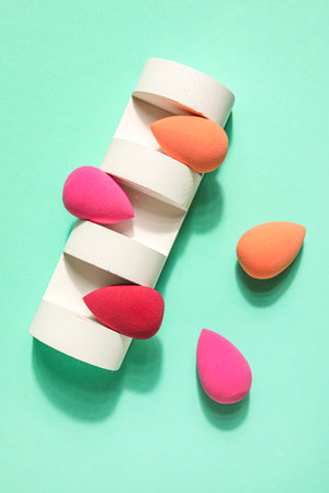 Stand with makeup sponges on green backgroundの写真素材