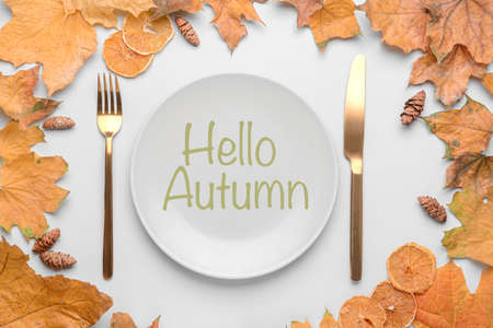 Table setting with autumn leaves on white backgroundの写真素材