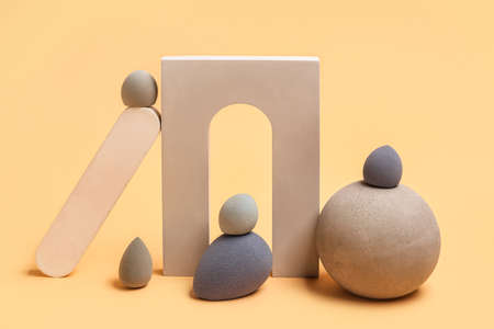 Gray makeup sponges with decor on beige background