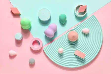 Makeup sponges with decor on pink and blue background
