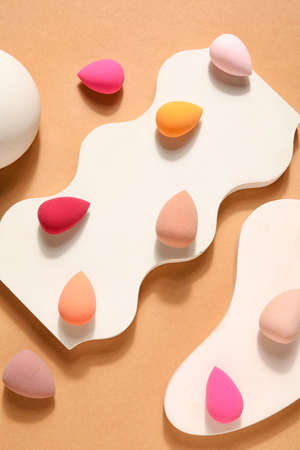 Stands with makeup sponges on beige backgroundの写真素材