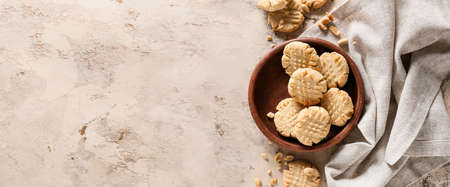 Bowl with tasty peanut cookies on grunge background with space for textの写真素材