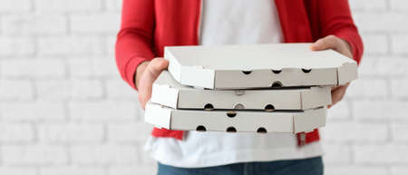 Delivery man holding cardboard pizza boxes on white background, closeupの写真素材