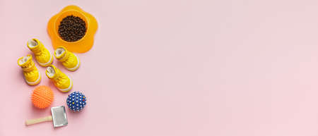Different pet accessories and food on light pink background with space for text, top viewの写真素材
