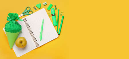 School cone, apple and stationery on yellow background with space for text, top viewの写真素材