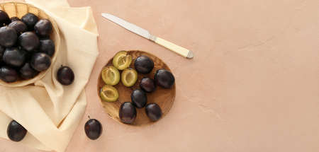 Composition with ripe plums on beige table with space for textの写真素材