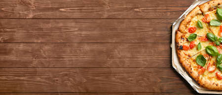 Cardboard box with delicious pizza Margherita on wooden background with space for textの写真素材