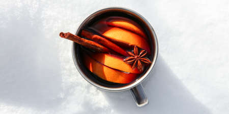 Mug of delicious mulled wine on snow, top viewの写真素材