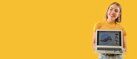 Pretty young woman holding laptop on yellow background with space for text. online shopping