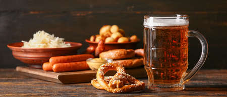 Mug of fresh beer and tasty snacks on table. Oktoberfest celebrationの写真素材