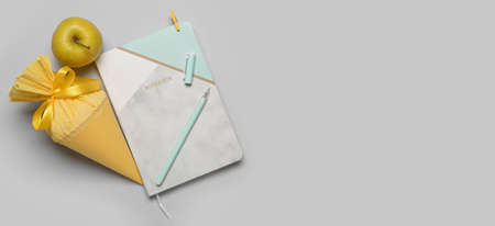 School cone, apple and stationery on gray background with space for text, top view