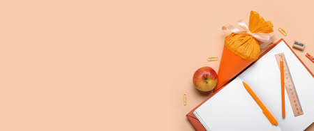 School cone, apple and stationery on beige background with space for textの写真素材