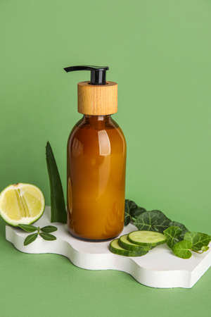 Plaster stand with bottle of natural cosmetic product on green backgroundの写真素材
