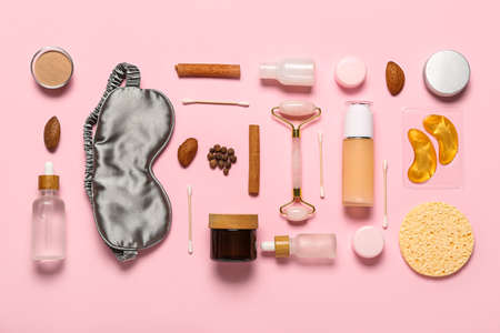 Facial massage tool with cosmetic products and ingredients on pink backgroundの写真素材