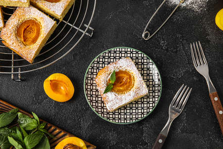 Plate with piece of tasty apricot pie on dark backgroundの写真素材