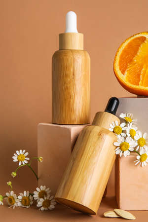 Composition with bottles of essential oil, chamomile flowers and plaster decor on color background, closeupの写真素材