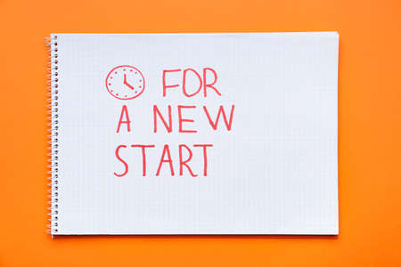 Notebook with text FOR A NEW START on orange backgroundの写真素材