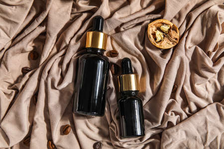 Composition with bottles of essential oil and coffee beans on fabric backgroundの写真素材