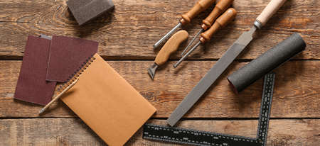 Set of carpenter's tools on wooden background, top view