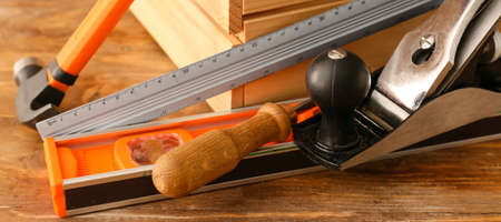 Set of different carpenter's tools on wooden background, closeup