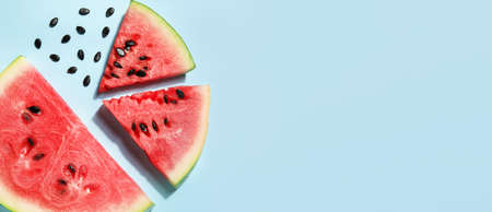 Slices of tasty watermelon on blue background with space for textの写真素材