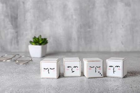 White cubes with different drawn emoticons on grunge background