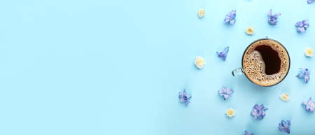 Cup of coffee with spring flowers on light blue background with space for text, top viewの写真素材