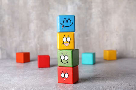 Colorful cubes with different drawn emoticons on grunge backgroundの写真素材
