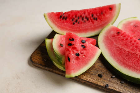 Cutting board with slices of watermelon on white background, closeupの写真素材