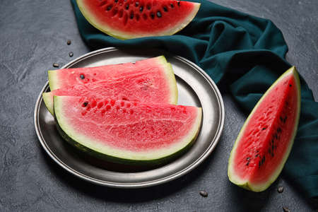 Plate with slices of watermelon and napkin on dark backgroundの写真素材