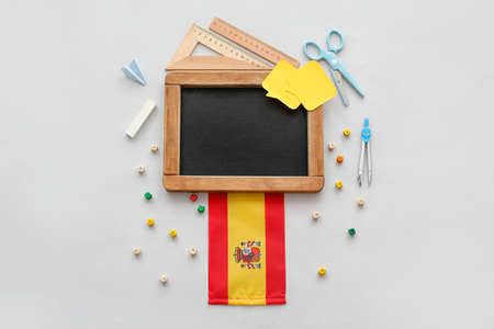 Chalkboard with stationery and flag of Spain on gray backgroundの写真素材