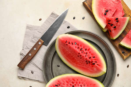 Plate, board with slices of watermelon, napkin and knife on white backgroundの写真素材