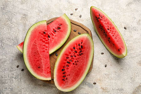 cutting board with slices of watermelon on grunge backgroundの写真素材