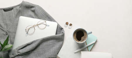 Woman's clothes, accessories, laptop and cup of coffee on light backgroundの写真素材