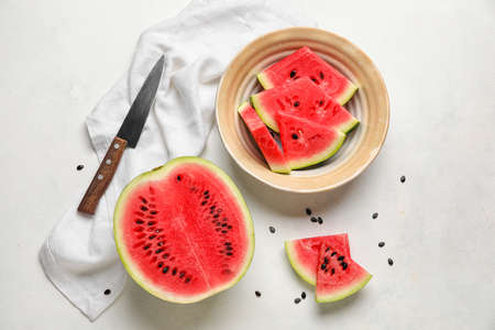 Plate with slices of watermelon, knife and napkin on white backgroundの写真素材