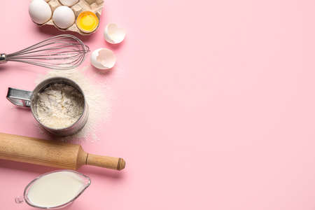 Ingredients for baking and kitchen utensils on pink backgroundの写真素材