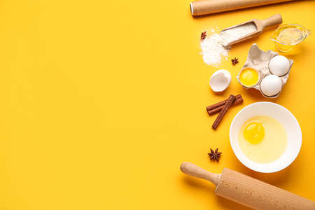 Different ingredients for baking and rolling pin on color backgroundの写真素材