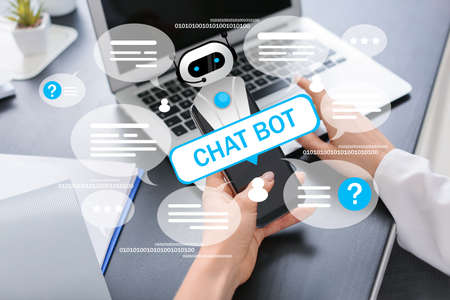 Woman with laptop and mobile phone chatting with bot in office