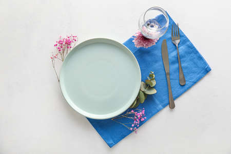 Simple table setting with floral decor on white background
