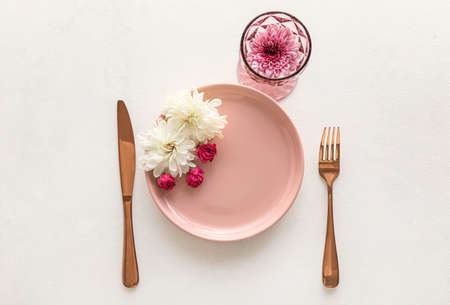 Beautiful table setting with chrysanthemum flowers and roses on white backgroundの写真素材